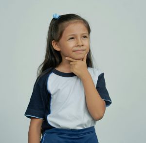 child questioning. With hand placed on her chin.